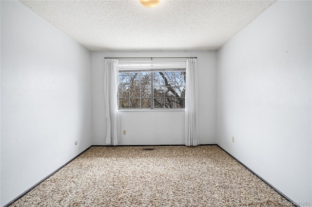 carpeted spare room featuring a textured ceiling