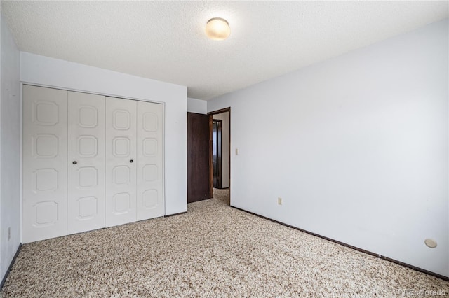 unfurnished bedroom with a textured ceiling, a closet, and carpet flooring