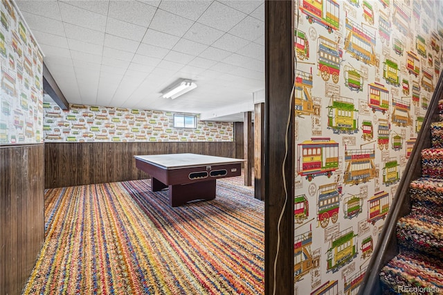 rec room featuring wooden walls, carpet flooring, and wainscoting
