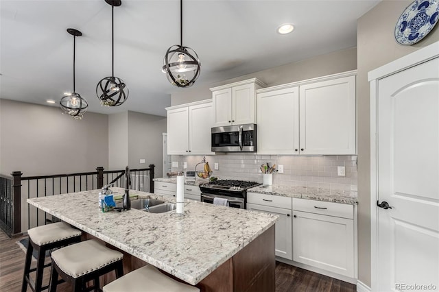 kitchen with white cabinetry, pendant lighting, stainless steel appliances, and sink