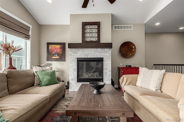 living room featuring ceiling fan, hardwood / wood-style floors, lofted ceiling, and a brick fireplace