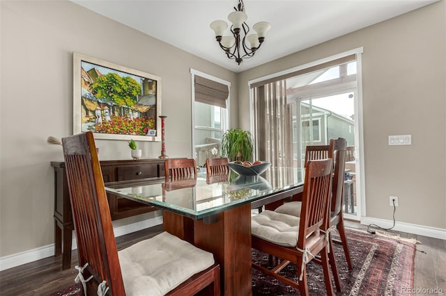 dining area with dark wood-type flooring, a chandelier, and plenty of natural light