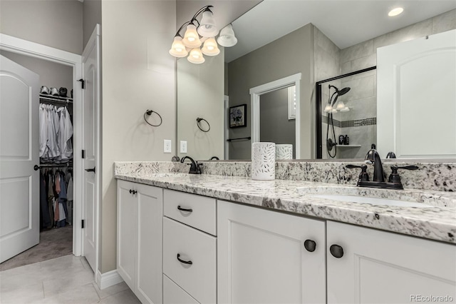 bathroom with tile patterned flooring, vanity, and a shower with shower door