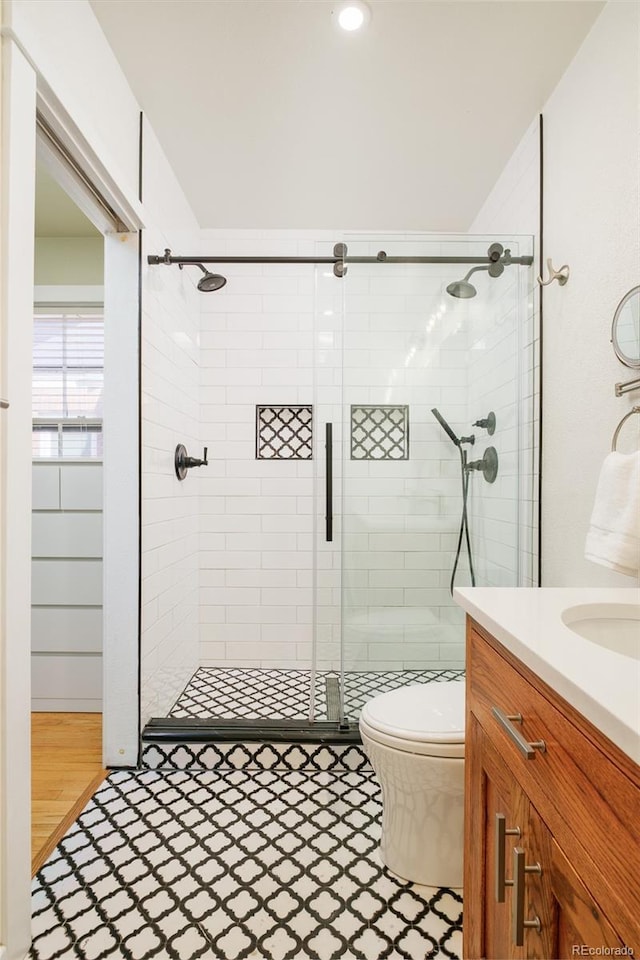 full bathroom with vanity, toilet, and a stall shower