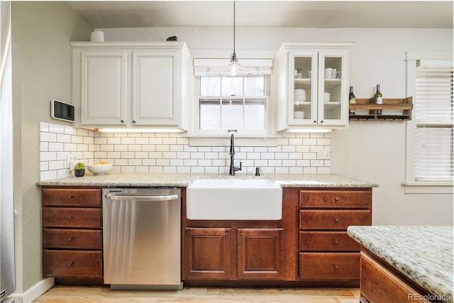 kitchen featuring a sink, decorative backsplash, glass insert cabinets, and dishwasher