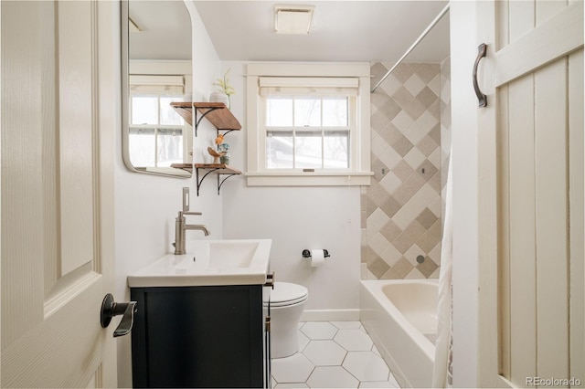 bathroom with vanity, baseboards, shower / bath combination, tile patterned floors, and toilet