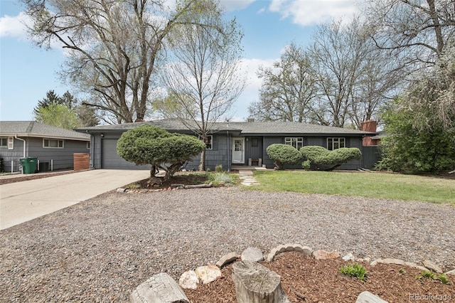 single story home with driveway, an attached garage, a front yard, and a chimney