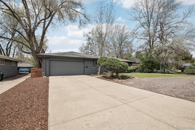 view of front of property with driveway, a garage, and a chimney