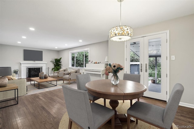 dining area featuring dark wood-style flooring, french doors, recessed lighting, a premium fireplace, and baseboards