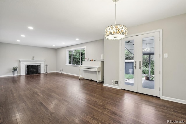 unfurnished living room with french doors, dark wood finished floors, recessed lighting, and baseboards