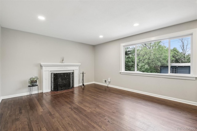 unfurnished living room featuring a fireplace, wood finished floors, baseboards, and recessed lighting