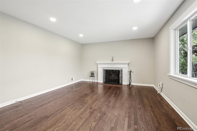 unfurnished living room featuring wood finished floors, a fireplace, recessed lighting, and baseboards