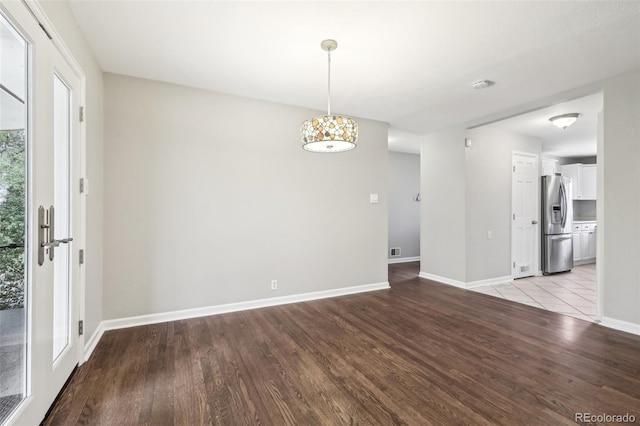 unfurnished dining area with light wood-style flooring and baseboards