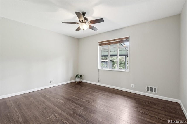 spare room with a ceiling fan, baseboards, and dark wood finished floors
