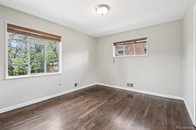unfurnished room featuring baseboards and dark wood-style flooring