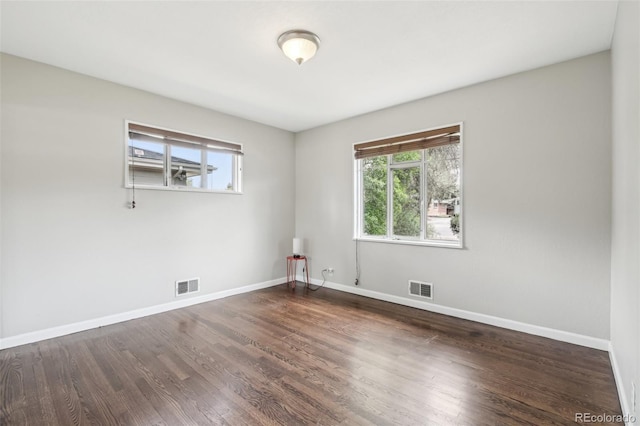 empty room featuring baseboards and dark wood-style flooring