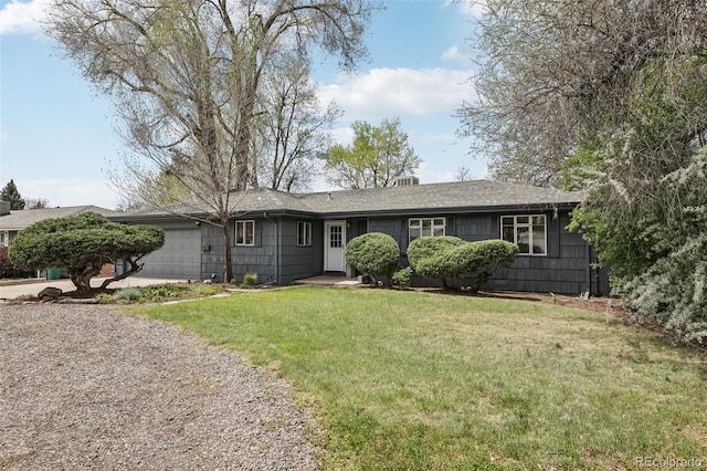 ranch-style home with a garage, driveway, a front lawn, and a shingled roof
