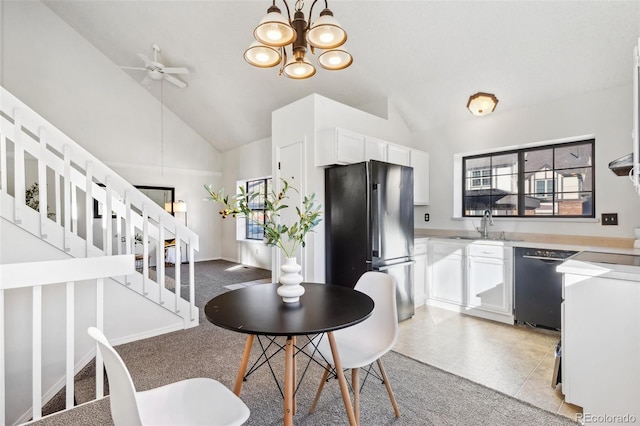 dining room featuring ceiling fan with notable chandelier, plenty of natural light, sink, and light carpet