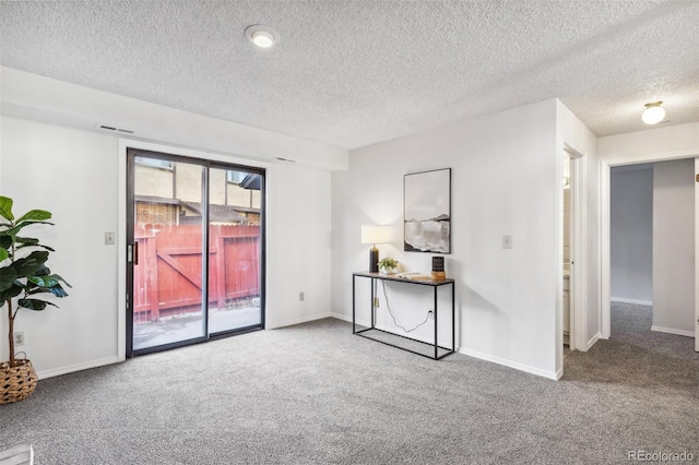 carpeted empty room with a textured ceiling