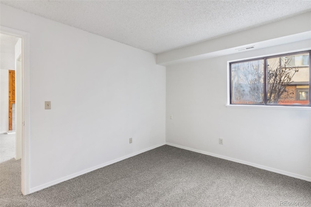 unfurnished room with a textured ceiling and carpet flooring