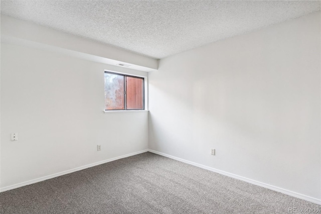 carpeted spare room with a textured ceiling