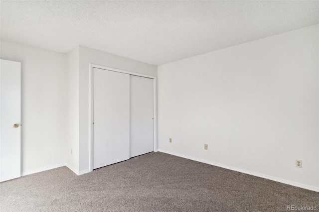 unfurnished bedroom with a textured ceiling, a closet, and carpet