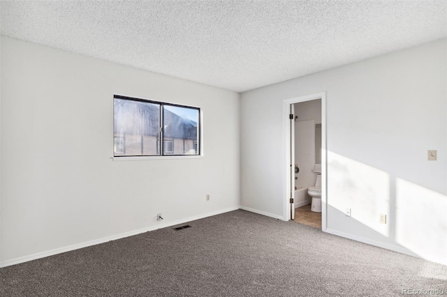 carpeted empty room featuring a textured ceiling