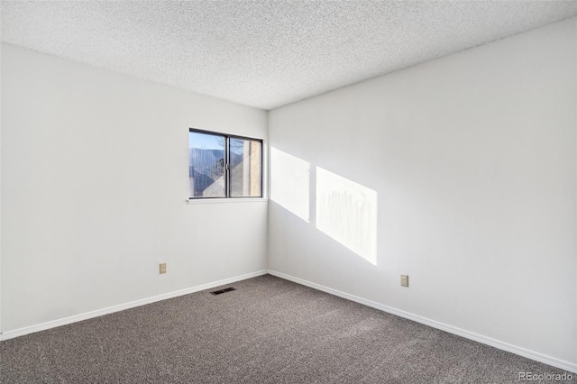 empty room featuring a textured ceiling and carpet flooring