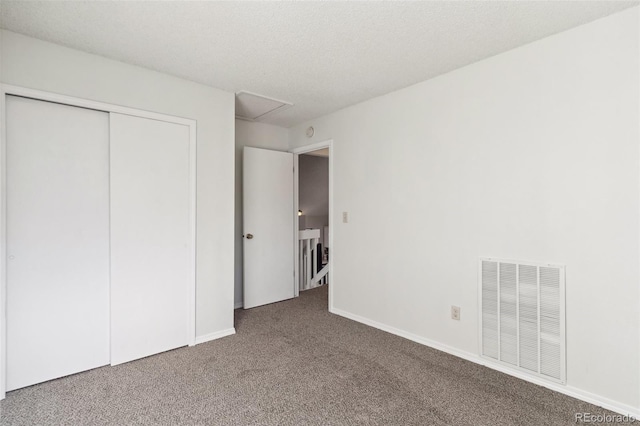 unfurnished bedroom with a textured ceiling, a closet, and carpet flooring