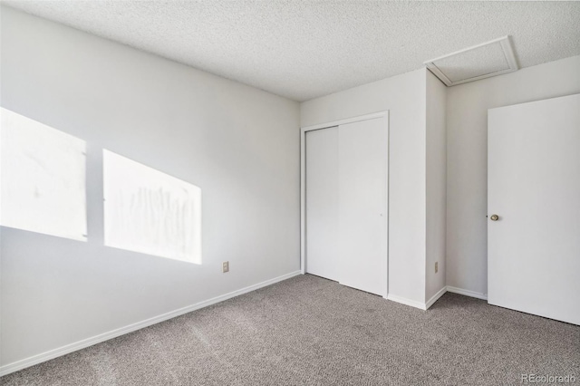 unfurnished bedroom with a textured ceiling, a closet, and carpet flooring