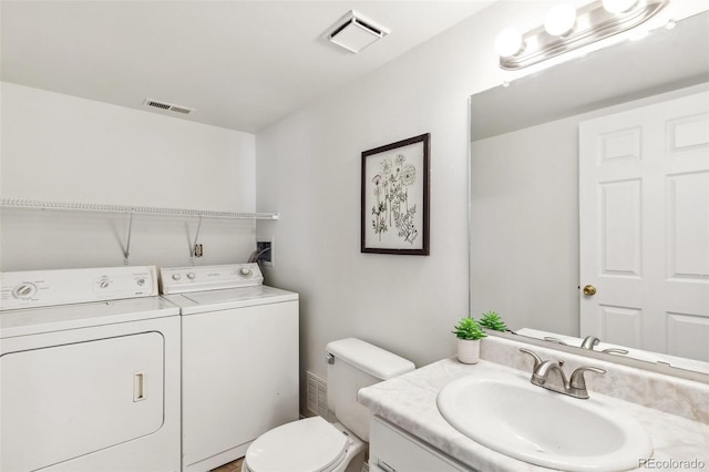 bathroom with toilet, independent washer and dryer, and vanity