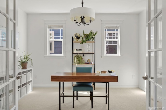 carpeted home office featuring baseboards, a healthy amount of sunlight, french doors, and a chandelier