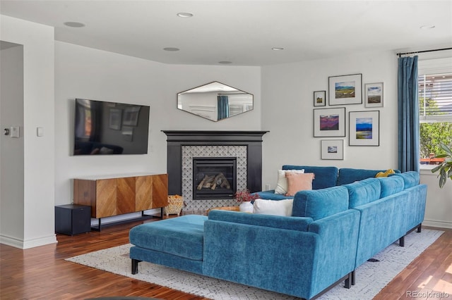 living area featuring baseboards, a fireplace, recessed lighting, and wood finished floors