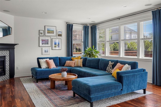 living room with a tile fireplace, baseboards, and hardwood / wood-style floors