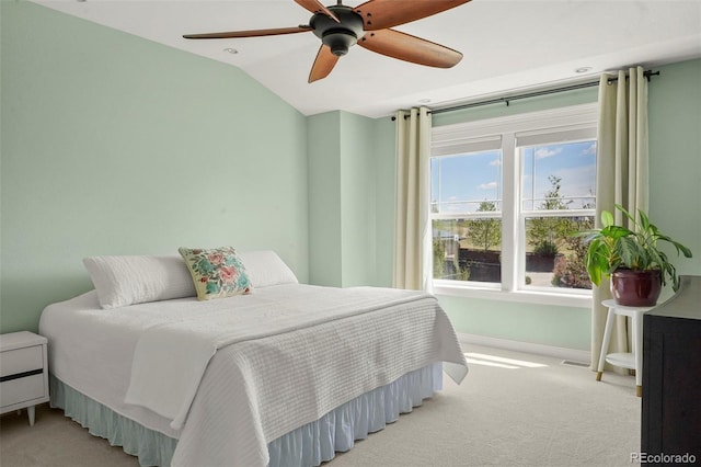 bedroom with light colored carpet, a ceiling fan, baseboards, and lofted ceiling