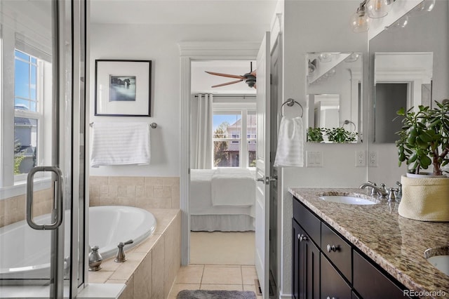 ensuite bathroom featuring ensuite bath, a sink, tile patterned floors, a garden tub, and double vanity
