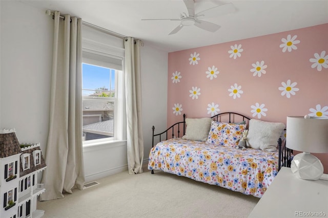 bedroom featuring visible vents, an accent wall, carpet floors, baseboards, and wallpapered walls