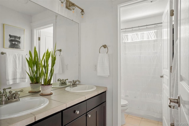 bathroom featuring a sink, double vanity, toilet, and tile patterned floors
