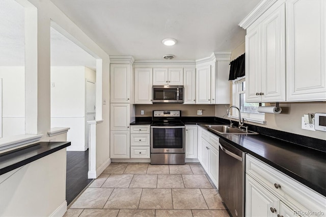 8641 Lowell Blvd, Westminster, CO 80031 - kitchen with stainless steel appliances, a sink, dark countertops, and white cabinetry