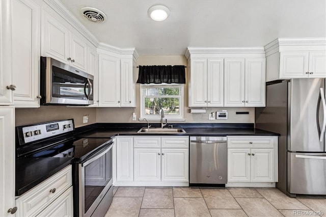 8641 Lowell Blvd, Westminster, CO 80031 - kitchen featuring stainless steel appliances, a sink, white cabinets, and dark countertops