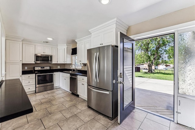 8641 Lowell Blvd, Westminster, CO 80031 - kitchen with appliances with stainless steel finishes, dark countertops, white cabinetry, recessed lighting, and light tile patterned flooring