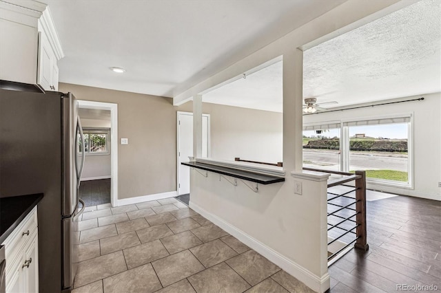 8641 Lowell Blvd, Westminster, CO 80031 - kitchen featuring baseboards, white cabinets, healthy amount of natural light, freestanding refrigerator, and recessed lighting