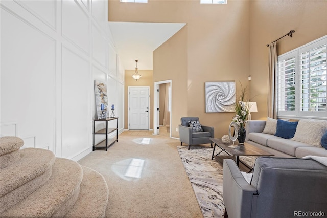 living area featuring a high ceiling and light colored carpet