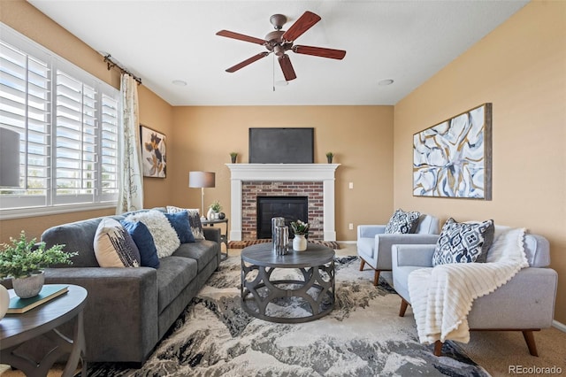 living room featuring baseboards, carpet, a brick fireplace, and ceiling fan