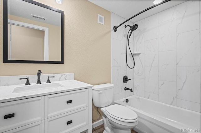 full bathroom with toilet, a textured wall, visible vents, and vanity