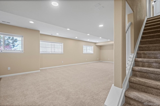below grade area with visible vents, stairs, carpet floors, baseboards, and recessed lighting