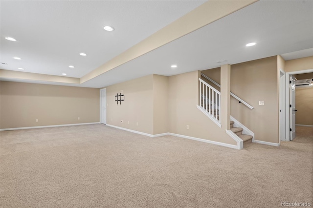 finished below grade area with baseboards, carpet, recessed lighting, and stairs