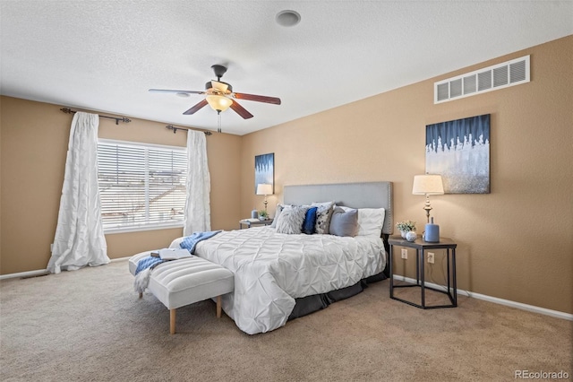 bedroom with a ceiling fan, a textured ceiling, visible vents, baseboards, and carpet flooring