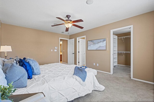 carpeted bedroom with baseboards, a ceiling fan, a closet, and a spacious closet