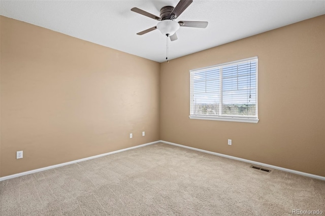 spare room with visible vents, a ceiling fan, carpet, and baseboards